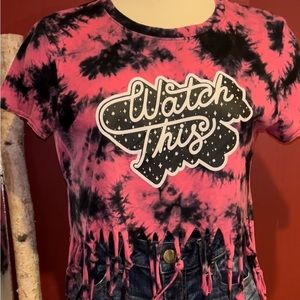 small tye dyed t shirt with word on front only. Tied off fringe on bottom
